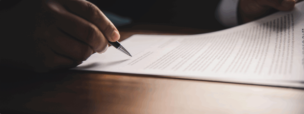 Hand hält Stift unterschreibt Vertrag wichtige Dokumente